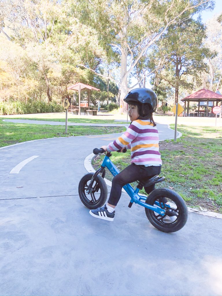 Toddler riding balance bike confidently